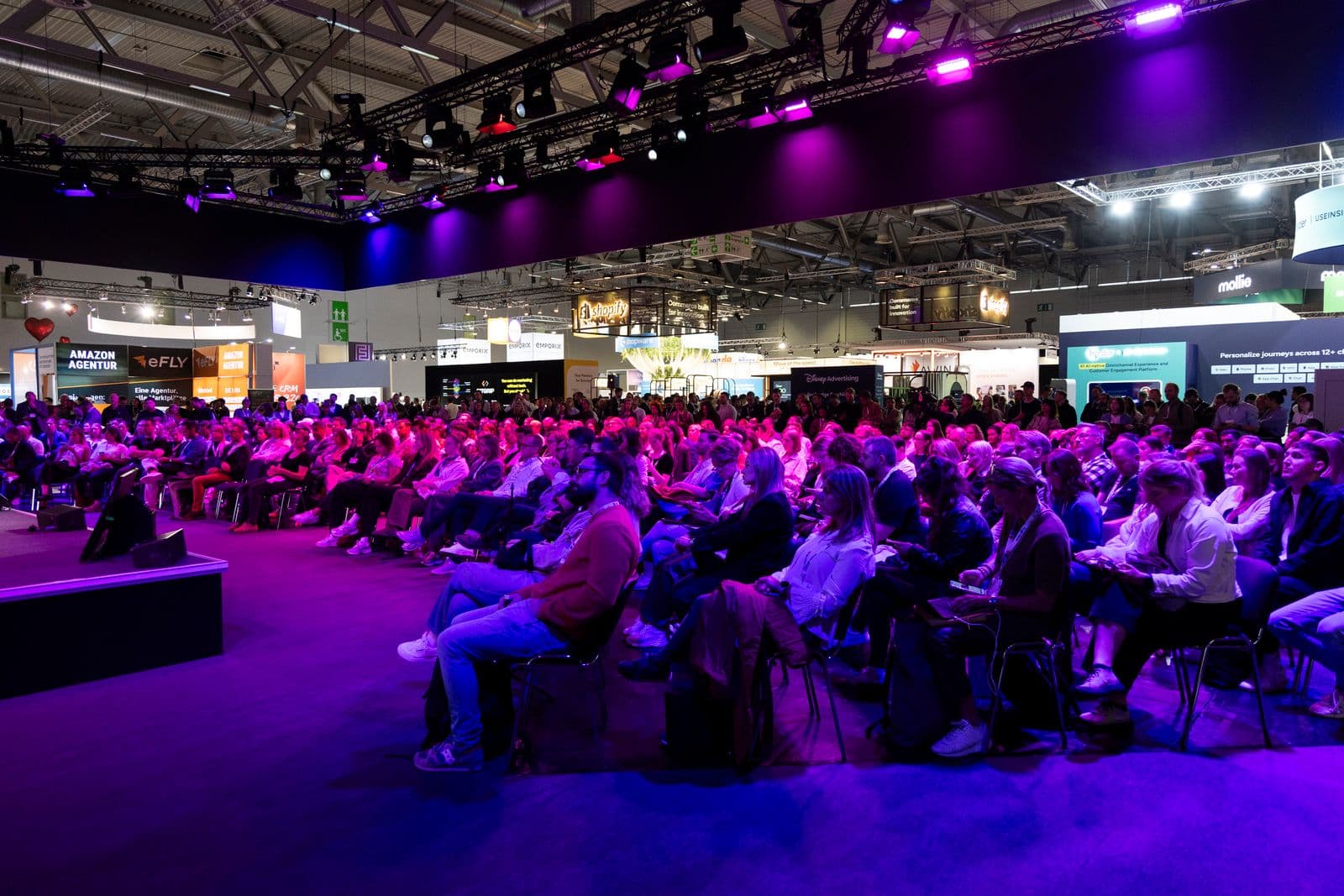 Besucherinnen und Besucher verfolgen ein Bühnenprogramm auf der DMEXCO 2025 in Köln.