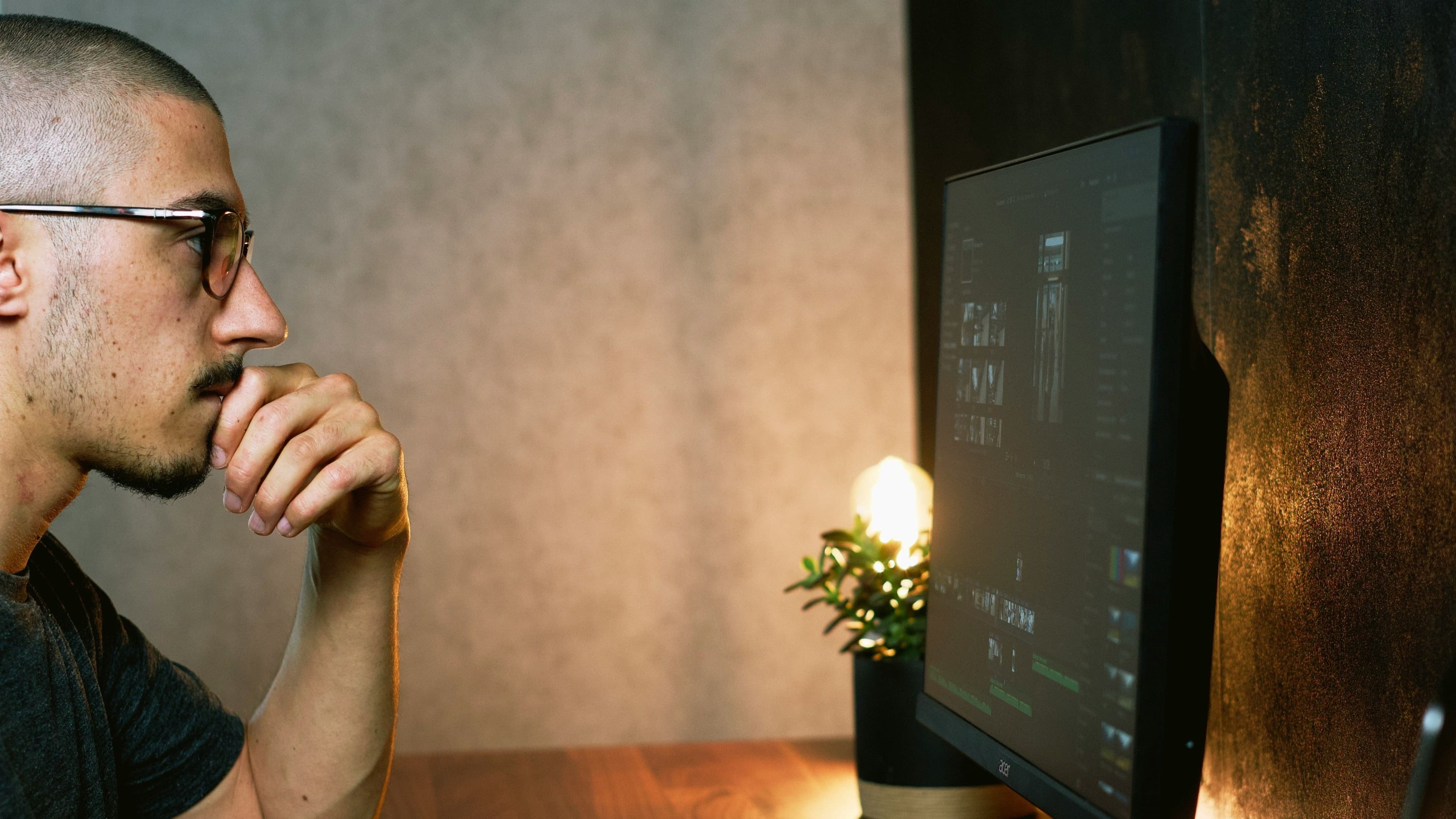 Mann betrachtet digitale Inhalte auf einem Monitor.