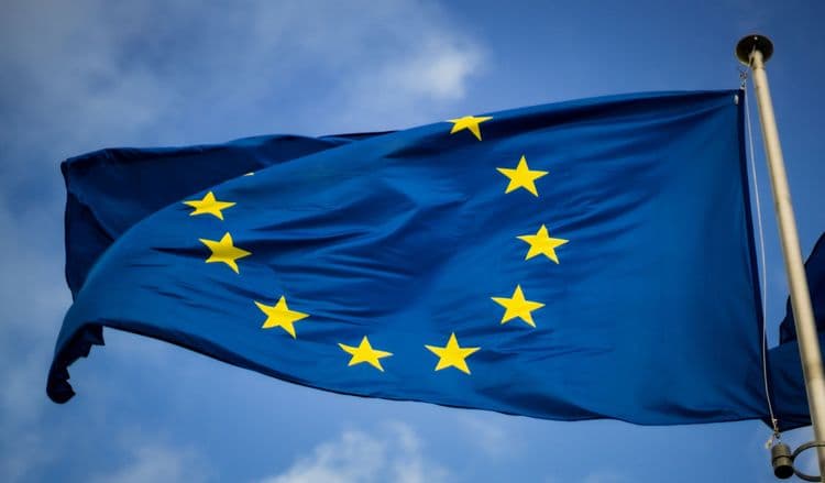 Eine EU-Flagge weht vor blauem Himmel.