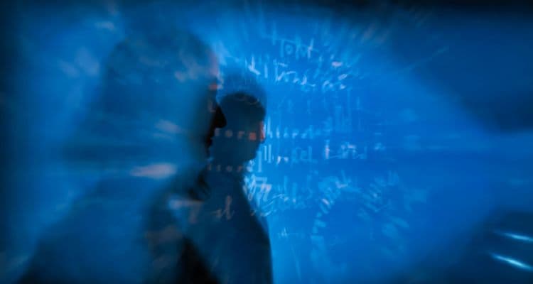 Menschliche Silhouette vor abstrakter blauer Datenprojektion als Symbol für KI und automatisierte Entscheidungen.