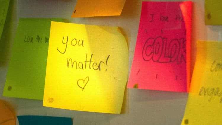Bunte Haftnotizen an einer Wand, auf einem gelben Zettel steht „You matter!“.
