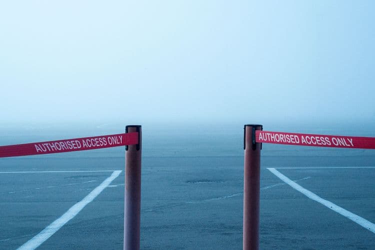 Zwei rote Absperrbänder mit der Aufschrift „Authorised Access Only“ lassen in der Mitte einen Durchgang frei.