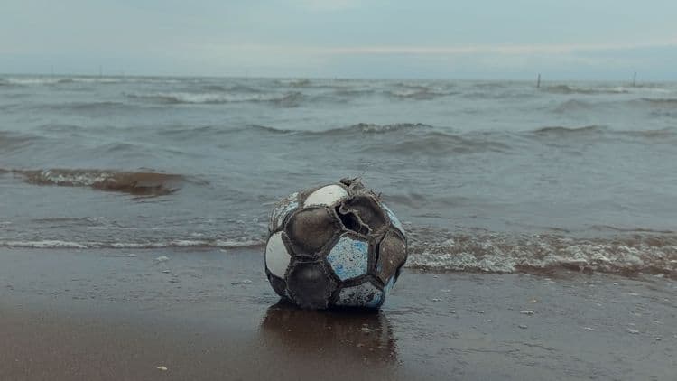 Kaputter Fußball am Ufer als Symbol für einen geplatzten WM-Traum.