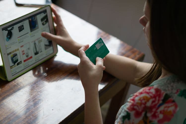 Person navigiert auf einem Touchscreen durch eine digitale Produktauswahl.