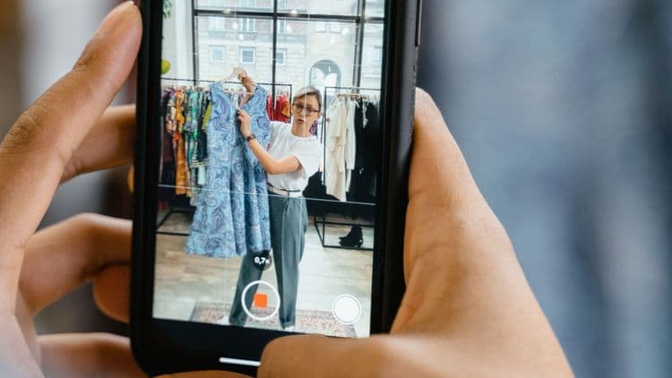 Smartphone-Aufnahme einer Person in einem Modegeschäft