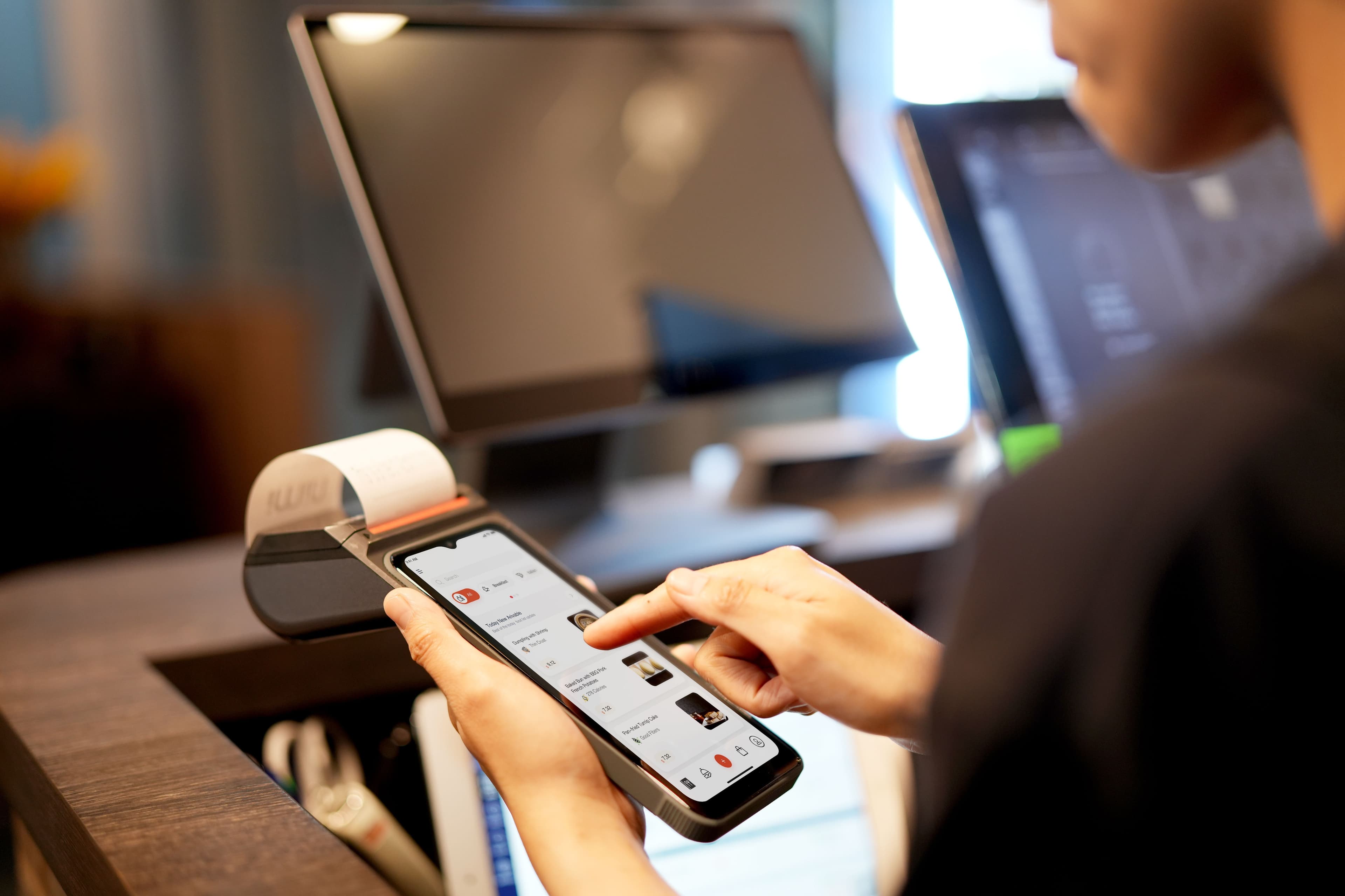 Person bedient ein digitales Kassengerät mit Bon und Touchscreen