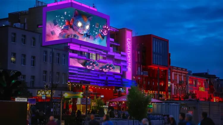 Visualisierung einer beleuchteten Gebäudefassade mit mehreren großen digitalen LED-Flächen am Hamburger Spielbudenplatz.