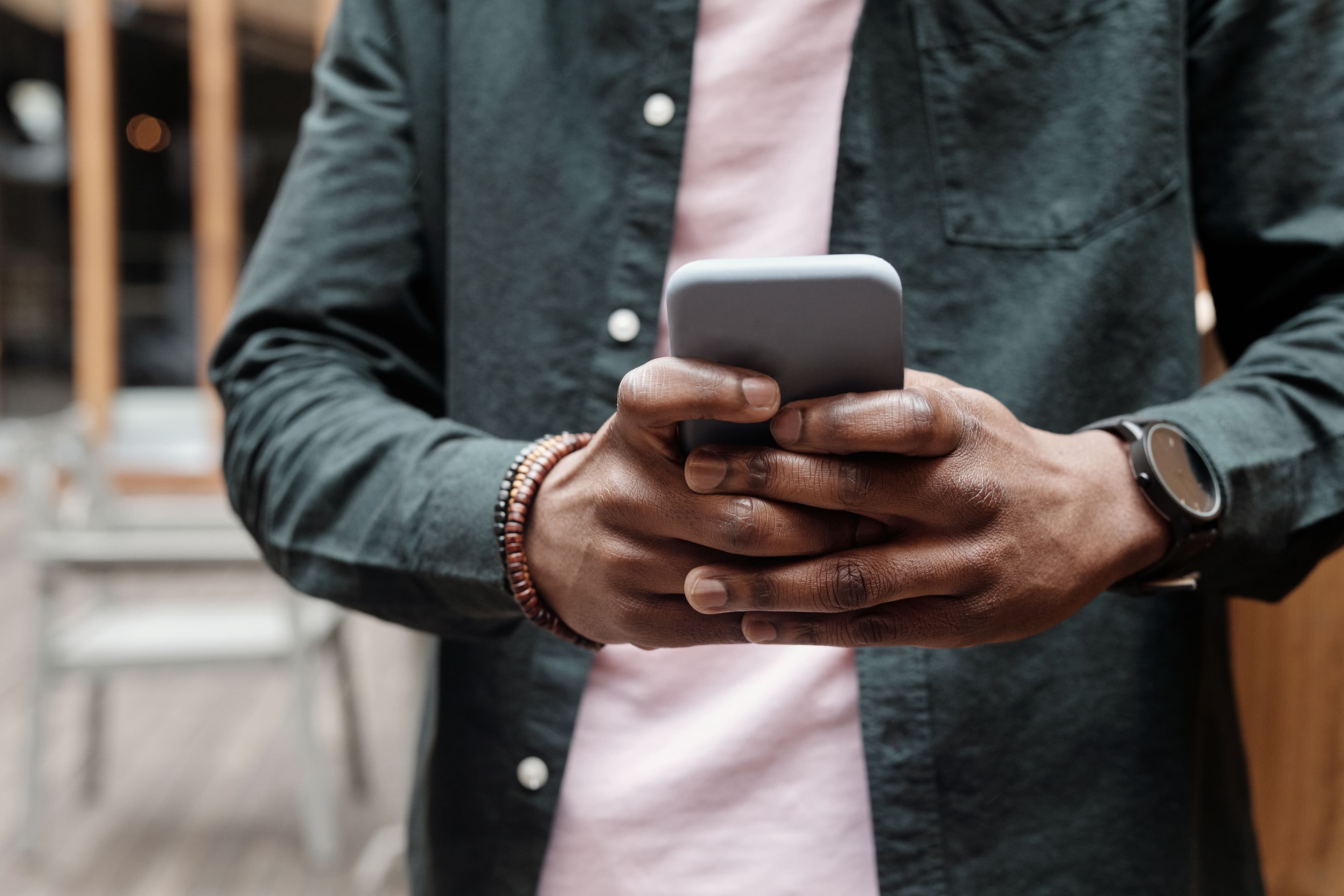 Person hält ein Smartphone mit beiden Händen.