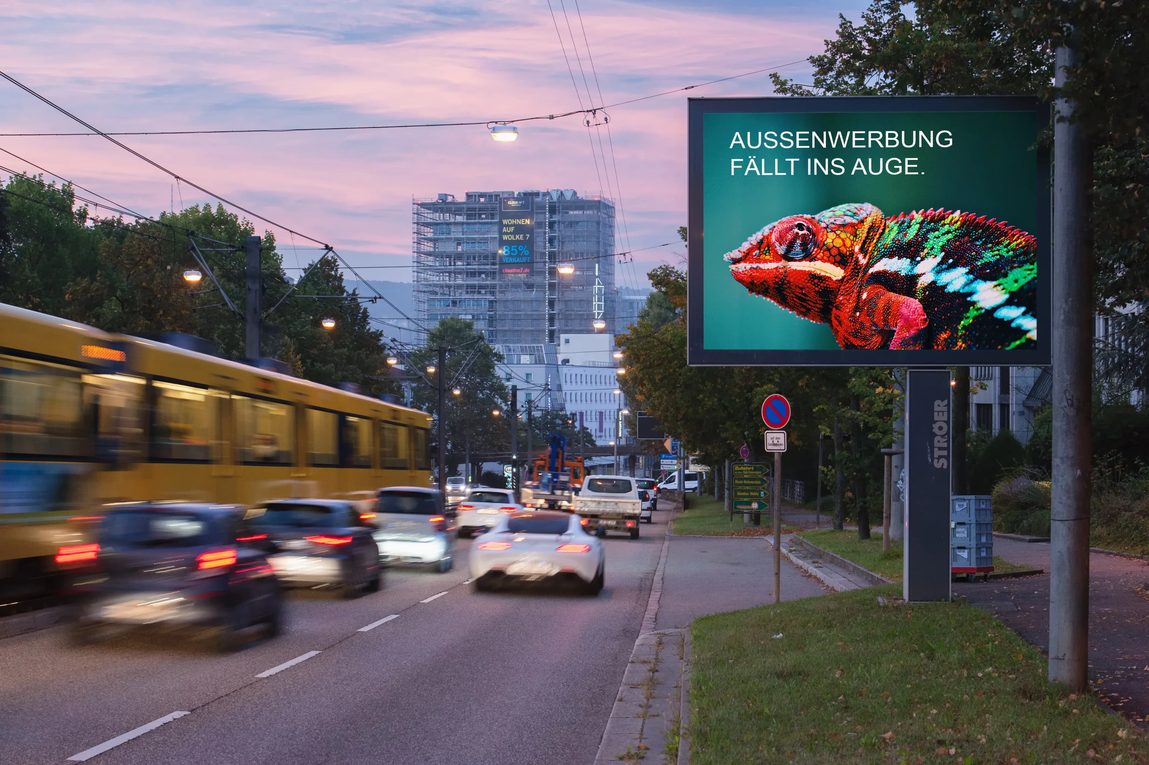 Digitale Außenwerbung in Stuttgart an einer Straße. Auf dem Display: Ein Chamäleon mit dem Claim darüber: "Außenwerbung fällt ins Auge."