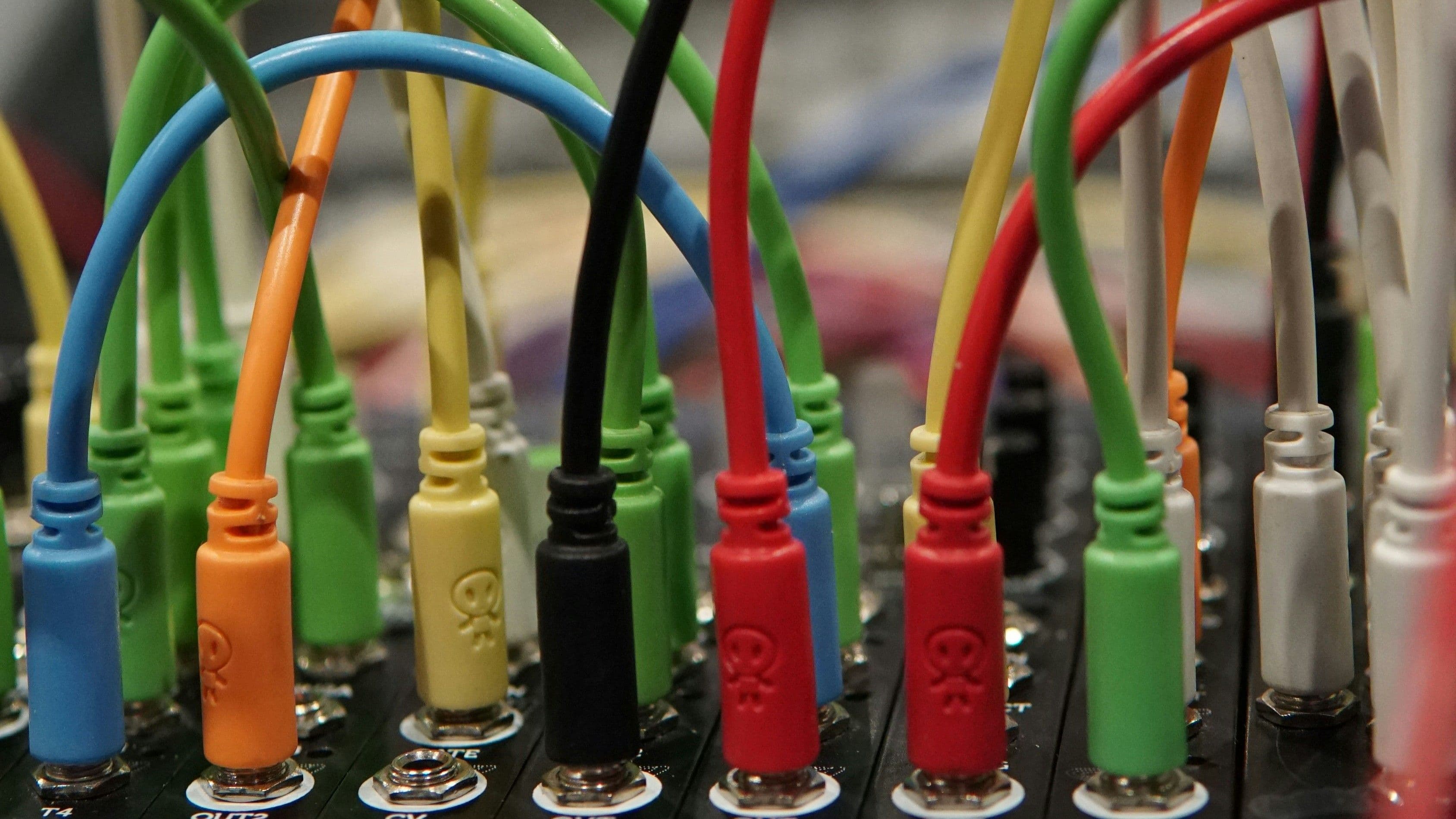 Mehrere farbige Kabel sind in eine technische Anschlussleiste eingesteckt.